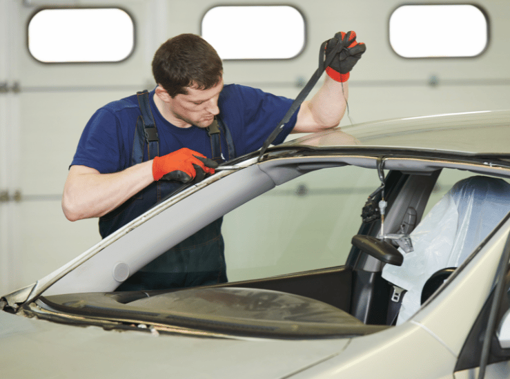Auto glass technician removing a damaged windshield